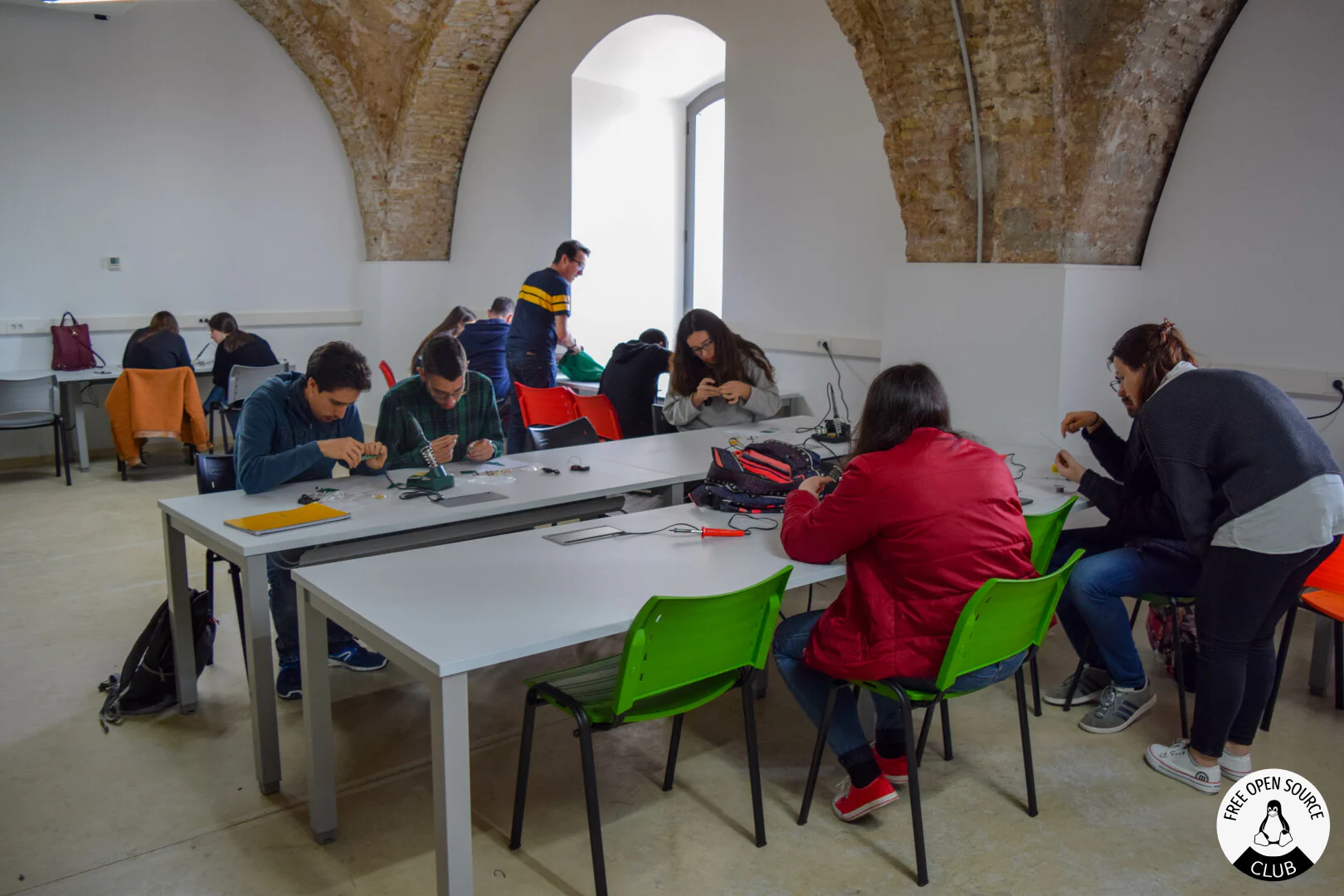 Room with many people sitting down soldering